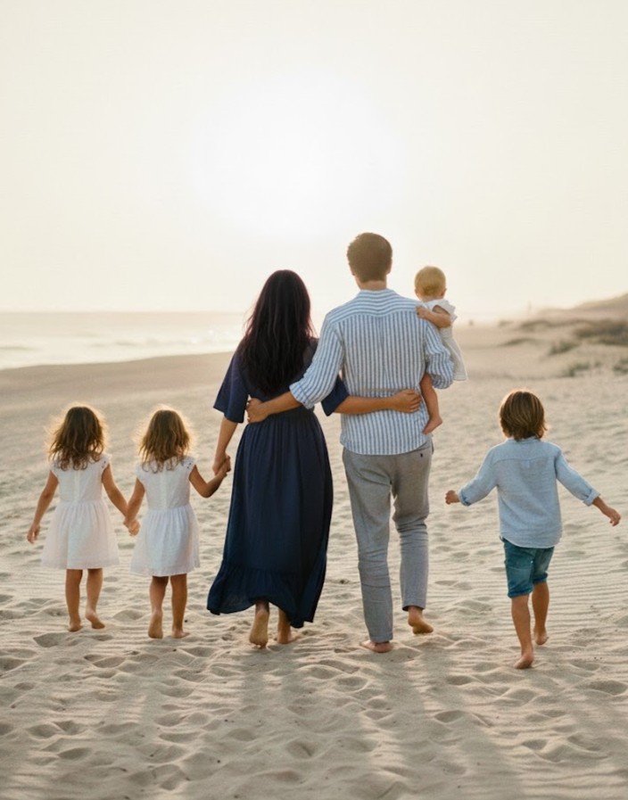 Família caminhando na praia ao pôr do sol, simbolizando união e apoio familiar
